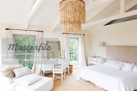 Chandelier and armchair in rustic bedroom