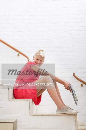 Woman sitting on steps of modern house