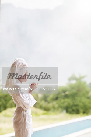 Woman in bathrobe drinking coffee outdoors