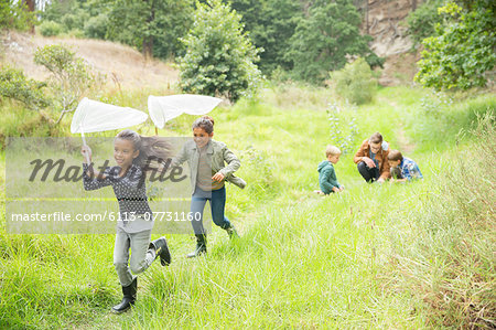 Children playing with butterfly nets on dirt path