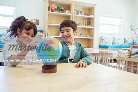 Students examining globe in classroom