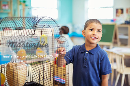 Student examining birdcage in classroom