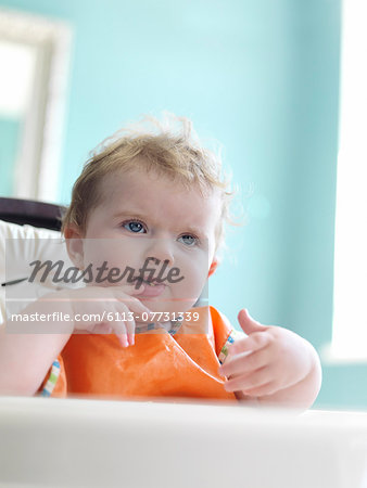 Baby girl eating in high chair