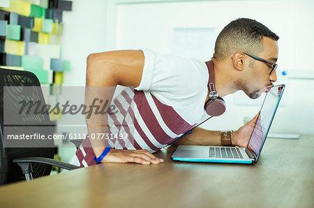 Man kissing laptop in office