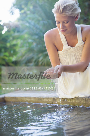 Woman cupping pool water in her hand