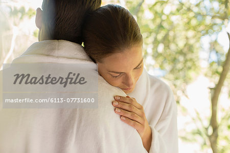 Couple in bathrobes hugging