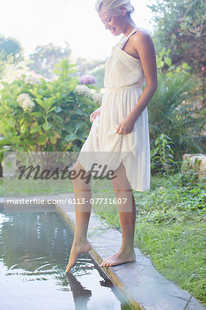 Woman dipping feet in pool