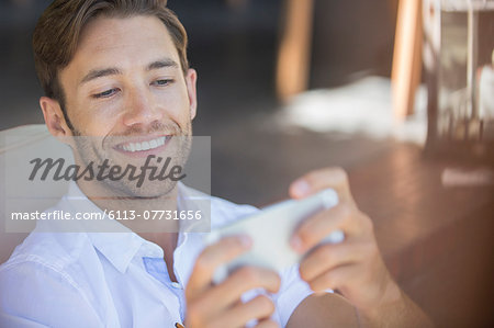 Man using cell phone in armchair