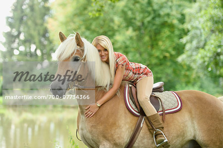 Close-up portrait of a young woman sitting on a Haflinger horse in summer, Upper Palatinate, Bavaria, Germany