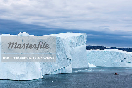 A Zodiac amongst huge icebergs calved from the Ilulissat Glacier, UNESCO World Heritage Site, Ilulissat, Greenland, Polar Regions