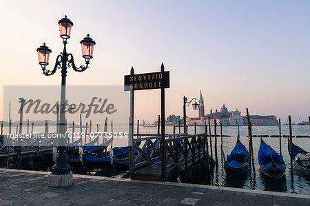 Gondolas moored on the Lagoon, San Giorgio Maggiore beyond, Riva degli Schiavoni, Venice, UNESCO World Heritage Site, Veneto, Italy, Europe