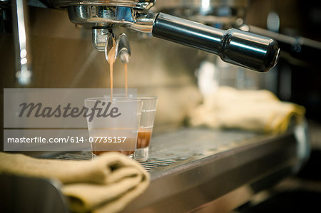 Close up of coffee machine pouring espresso in cafe