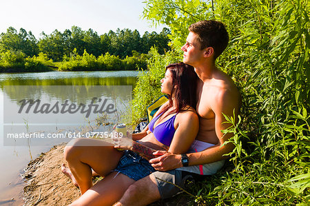 Young couple sitting on canal bank, Delaware Canal State Park, New Hope, Pennsylvania, USA