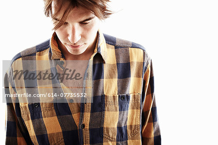 Studio portrait of young man looking down