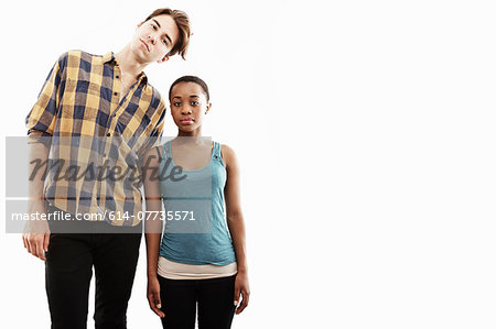 Studio portrait showing contrasting height of young couple Studio portrait showing contrasting height of young couple