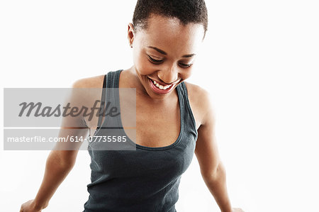 Studio shot of smiling young woman looking down