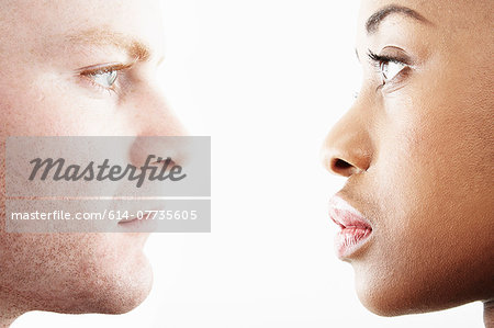 Cropped studio portrait of young couple face to face in profile