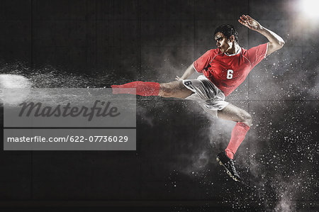 Soccer Player Kicking The Ball In Mid-Air Soccer Player Kicking The Ball In Mid-Air