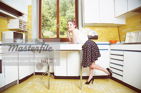 Portrait of young woman in vintage clothes in vintage kitchen