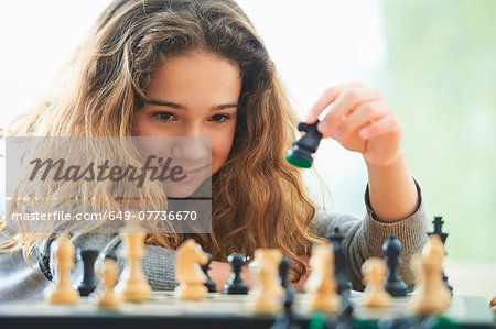 Portrait of young girl playing chess