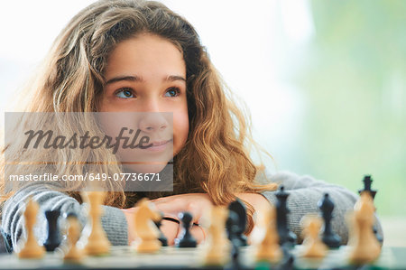 Portrait of young girl playing chess