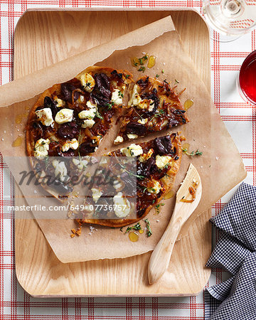 Caramelized onion pizza on chopping board