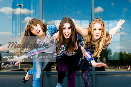 Three young women on one leg whilst leaning forward