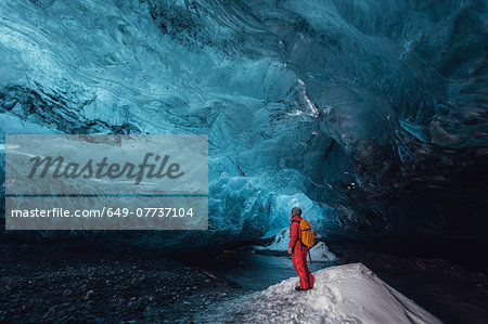 Man looking up in ice cave, Vatnajokull Glacier, Vatnajokull National Park, Iceland