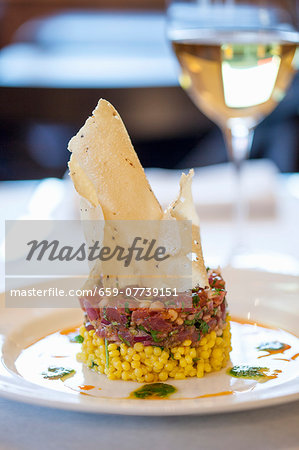 Tuna tartar on a bed of saffron couscous with green olives crispy poppadoms