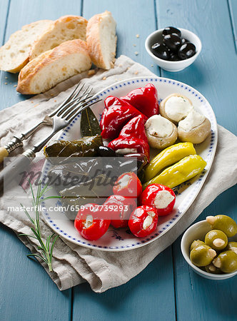 An appetiser platter with stuffed vine leaves and vegetables