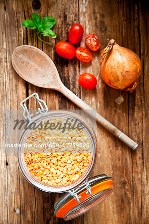 An arrangement of red lentils, date tomatoes and an onion