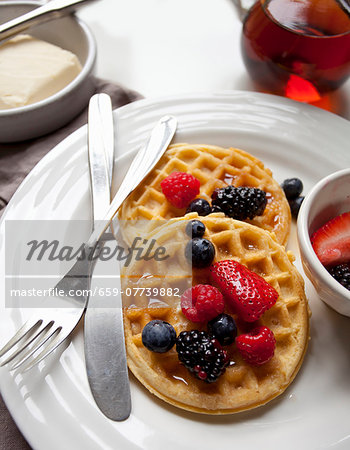 Waffles with butter, maple syrup and berries