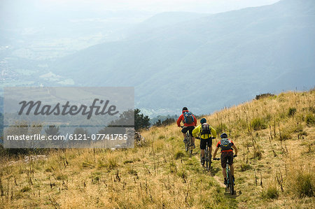 three mountain bikers on the way downhill, Matajur, Istria, Slovenia
