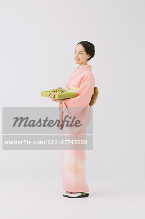 Young Japanese woman in a traditional kimono against white background