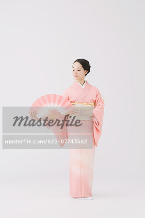 Young Japanese woman in a traditional kimono against white background