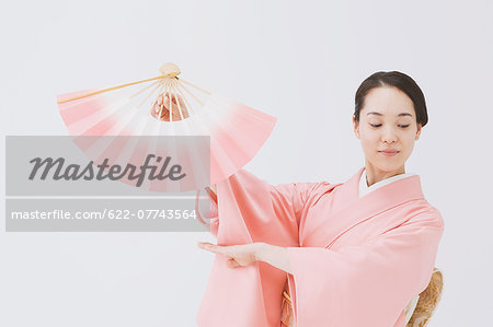 Young Japanese woman in a traditional kimono against white background