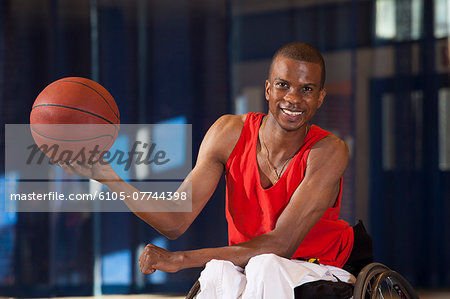 Man who had Spinal Meningitis in wheelchair holding basketball