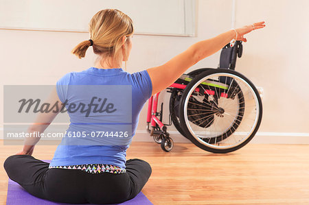 Young woman with a spinal cord injury doing a yoga pose in a studio