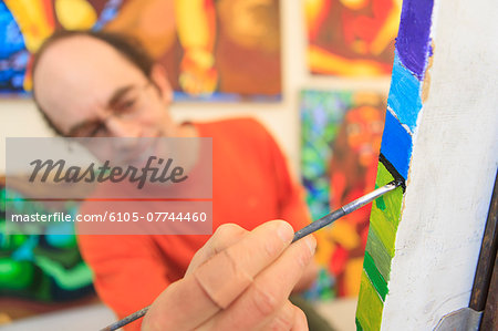 Man with aspergers painting in his art studio