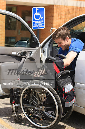 Man with spinal cord injury putting his wheelchair into his car