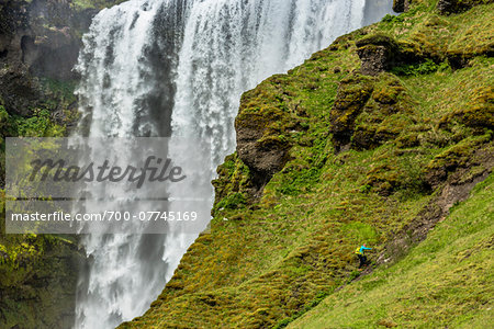 Person Climbing Slope by Skogafoss, Iceland