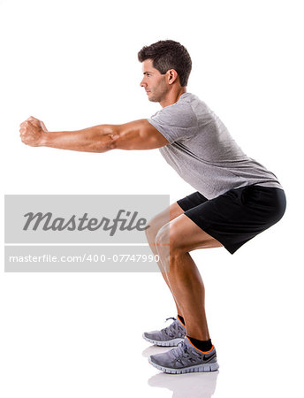 Athletic man running doing squats, isolated over a white background