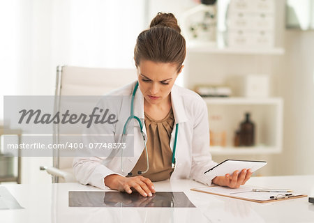 Doctor woman working with fluorography in office
