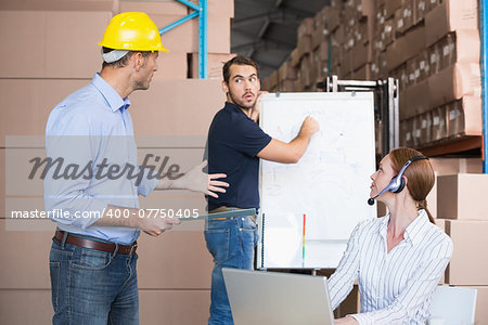 Warehouse team working together on shipment in a large warehouse