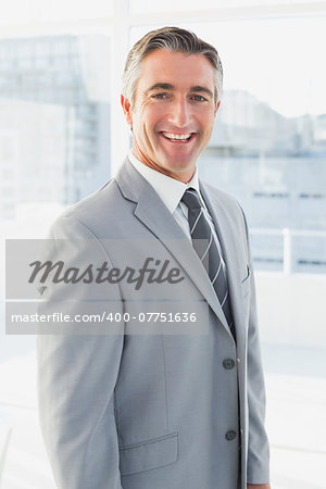 Businessman smiling at the camera from his workplace