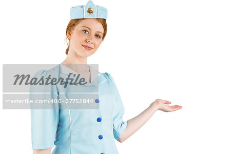 Pretty air hostess presenting with hand on white background