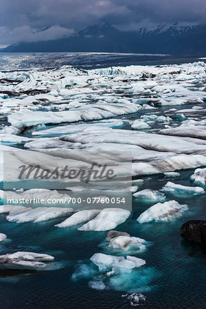 Senic view of glacial ice and lake water with mountains in background, Jokulsarlon, Iceland