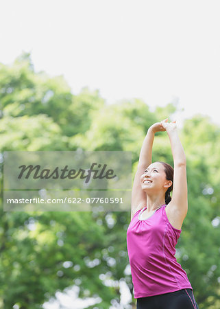 Young Japanese girl stretching in the park