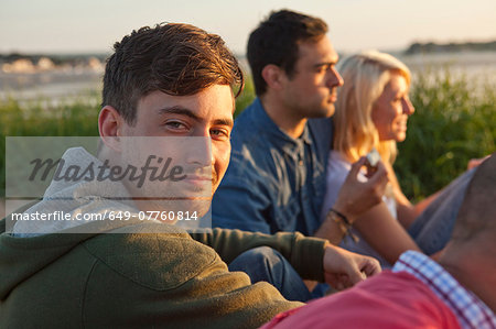 Four adult friends sitting on Bournemouth beach, Dorset, UK
