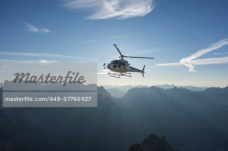 Helicopter on scenic flight at sunrise, Alleghe, Dolomites, Italy Helicopter on scenic flight at sunrise, Alleghe, Dolomites, Italy